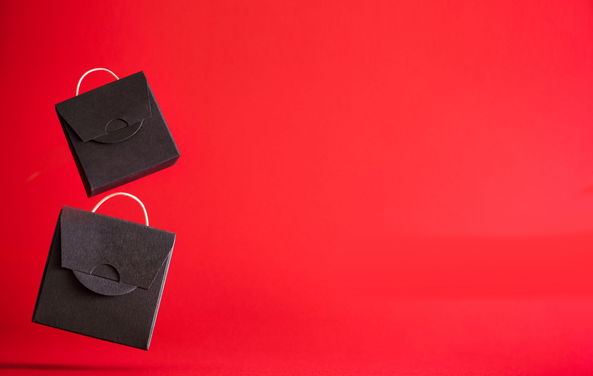 the concept of black friday. black gift bag  and red background. High quality photo with copy space